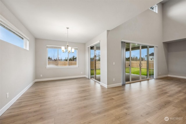 unfurnished dining area featuring light hardwood / wood-style floors and an inviting chandelier