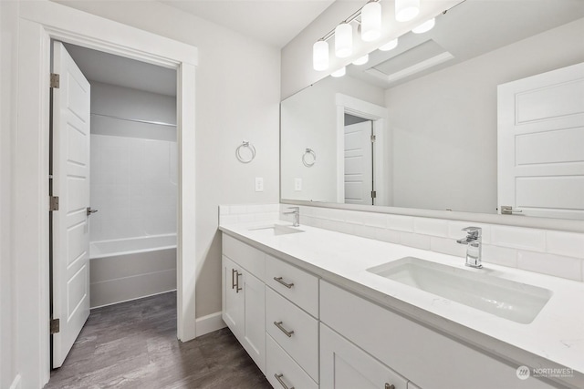 bathroom featuring decorative backsplash, vanity, wood-type flooring, and tub / shower combination