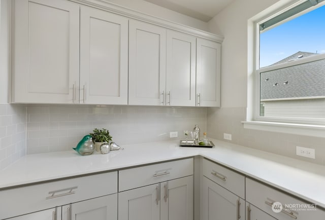 kitchen featuring tasteful backsplash and white cabinets