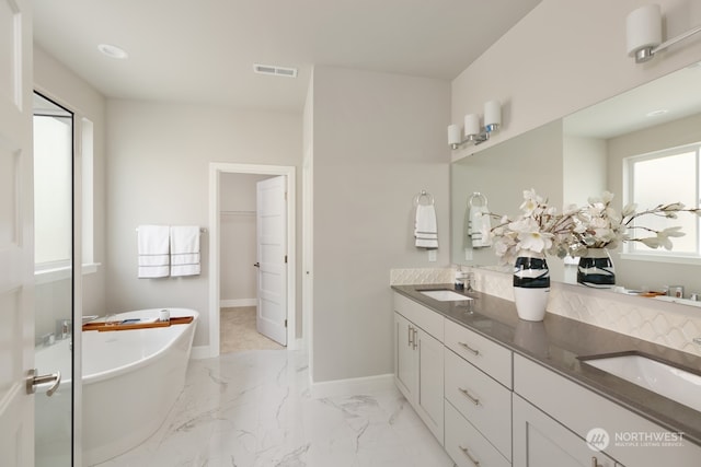 bathroom featuring vanity and a tub to relax in