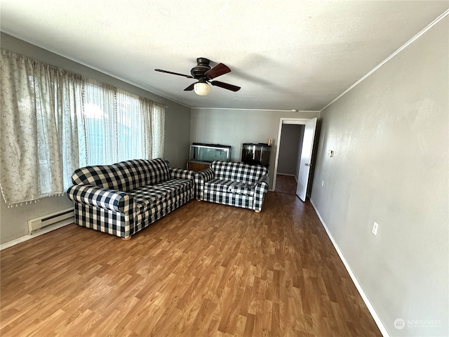 living room with ceiling fan, hardwood / wood-style floors, a textured ceiling, ornamental molding, and a baseboard radiator