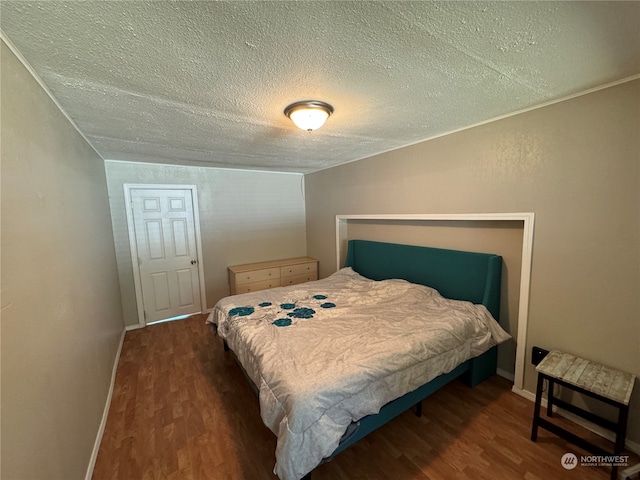 bedroom featuring dark hardwood / wood-style floors and a textured ceiling