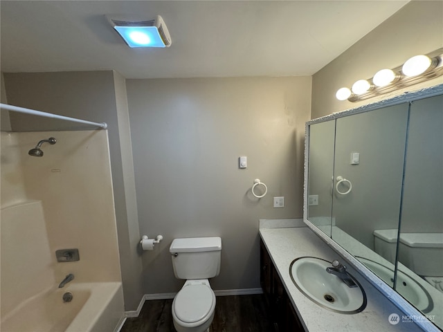 full bathroom featuring hardwood / wood-style flooring, vanity with extensive cabinet space, toilet, and shower / bathing tub combination