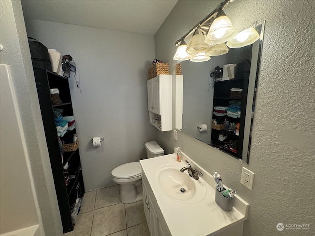 bathroom featuring tile floors, vanity, and toilet