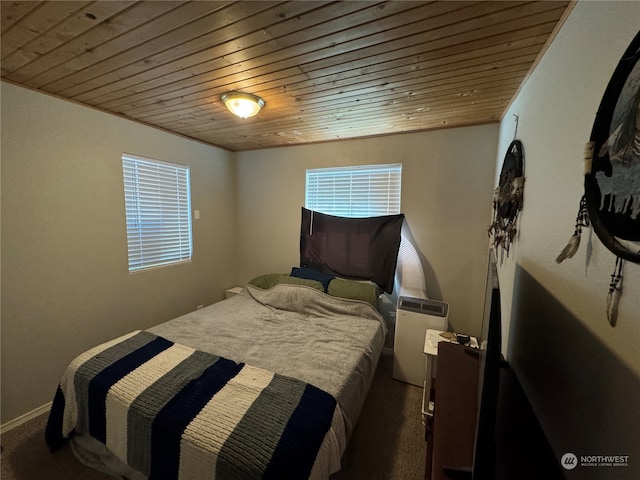 bedroom featuring dark colored carpet and wood ceiling