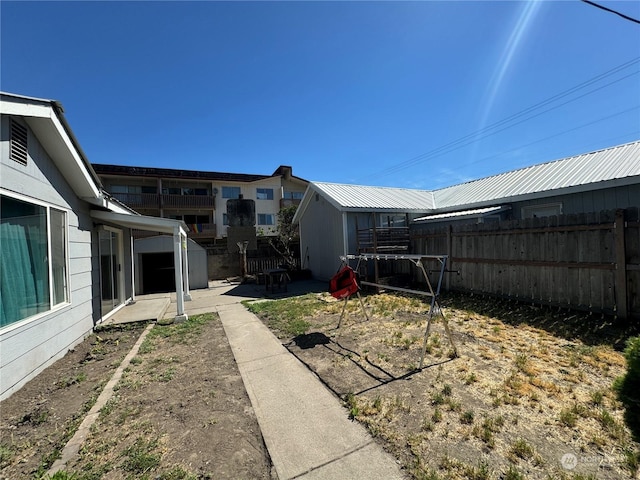 view of yard with a storage shed, an outdoor structure, a fenced backyard, and a patio