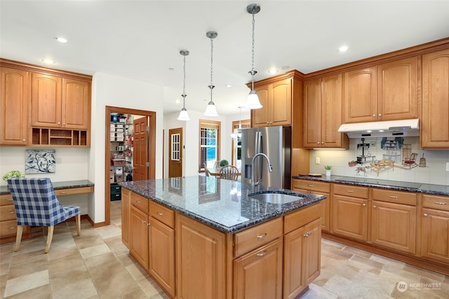 kitchen featuring stainless steel fridge, sink, hanging light fixtures, an island with sink, and black electric stovetop