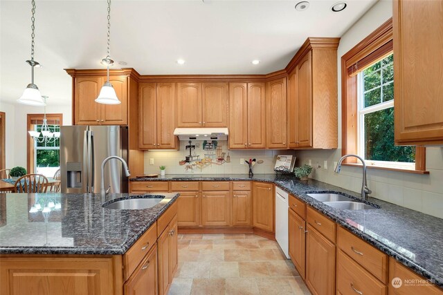 kitchen featuring stainless steel fridge, sink, and a healthy amount of sunlight