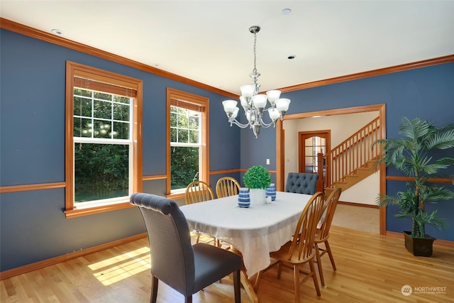 dining space featuring light hardwood / wood-style floors, a chandelier, and ornamental molding