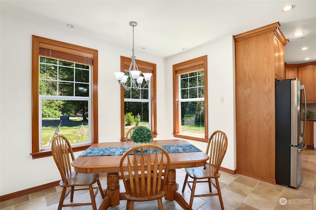 tiled dining room featuring a chandelier and a wealth of natural light