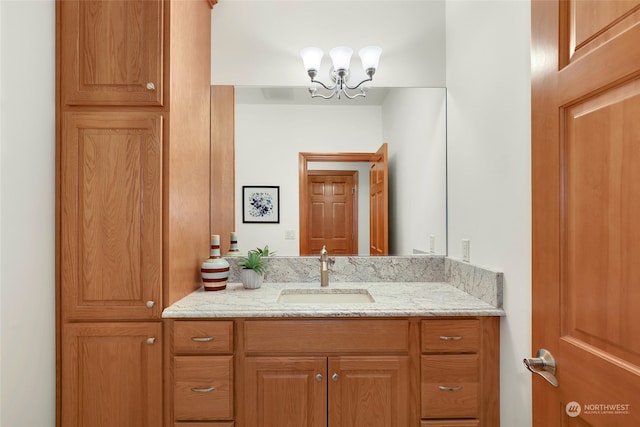 bathroom featuring a notable chandelier and vanity