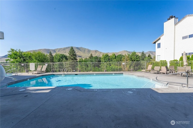 view of swimming pool featuring a mountain view and a patio