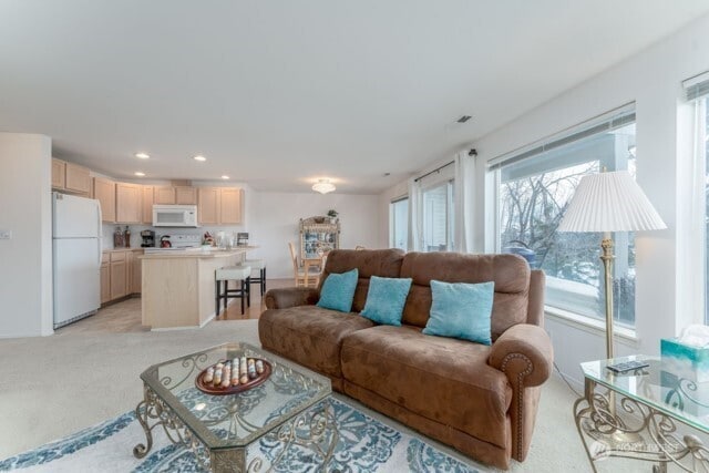 living room with recessed lighting, light colored carpet, and a wealth of natural light