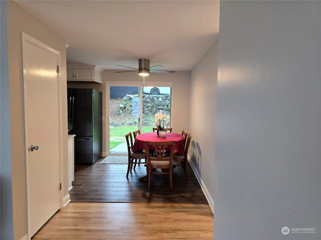 dining space featuring wood-type flooring and ceiling fan