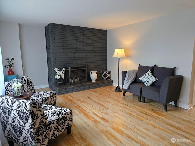 living room featuring hardwood / wood-style flooring and a brick fireplace