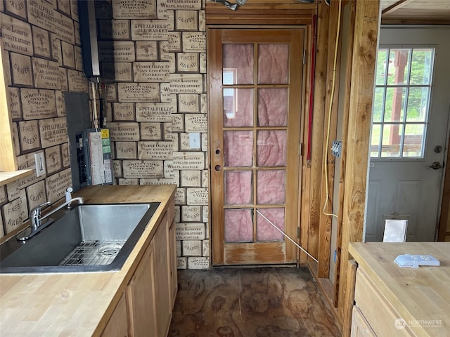 kitchen with sink, dark tile flooring, and wood counters