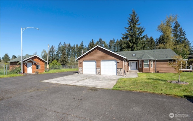 single story home featuring stone siding, fence, a garage, a front yard, and driveway