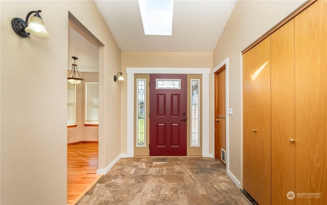 foyer featuring baseboards and stone finish floor