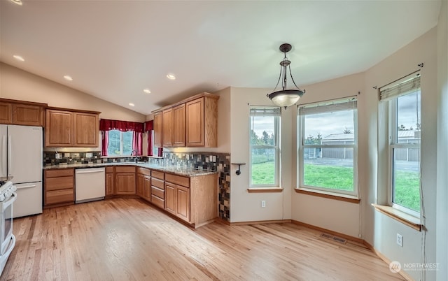 kitchen featuring backsplash, light hardwood / wood-style floors, white appliances, and lofted ceiling