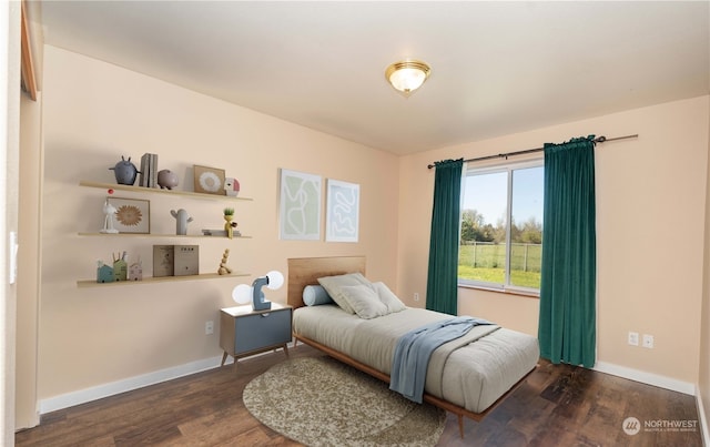 bedroom featuring baseboards and wood finished floors