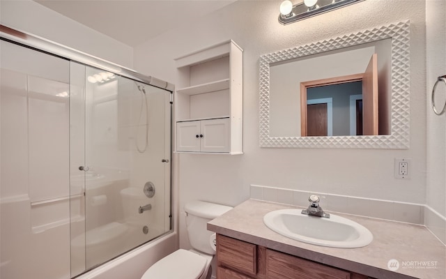 full bathroom with bath / shower combo with glass door, toilet, and vanity