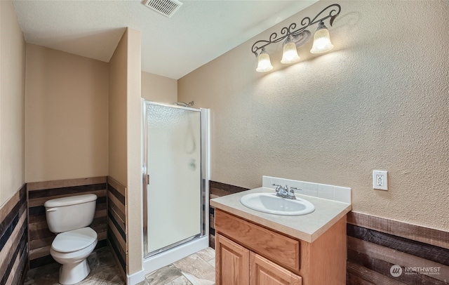 bathroom with a shower with door, a textured ceiling, tile floors, toilet, and vanity