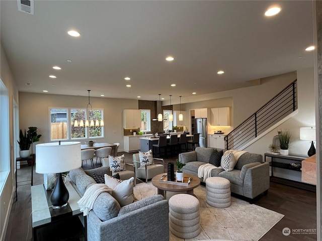 living room featuring a chandelier and dark wood-type flooring