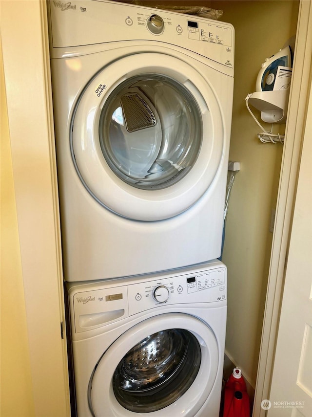 clothes washing area with stacked washer / dryer