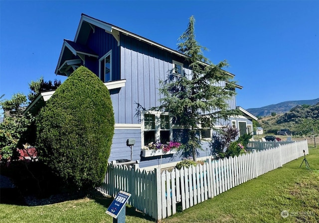 view of property exterior featuring a mountain view and a yard