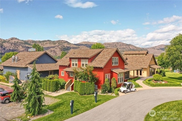 view of front facade featuring a mountain view and a front lawn