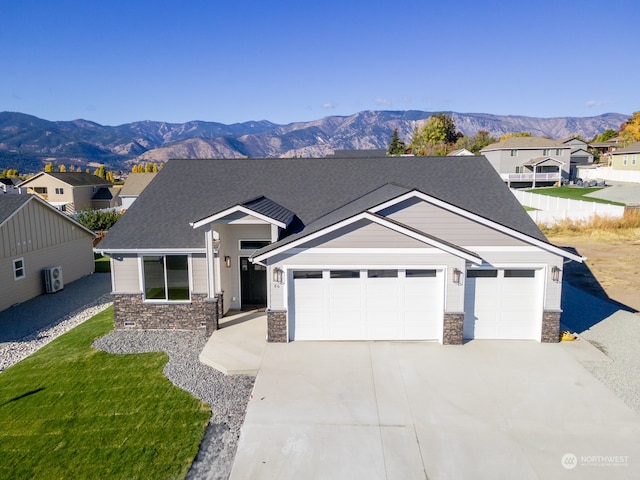 view of front of home with a front yard, a garage, and a mountain view