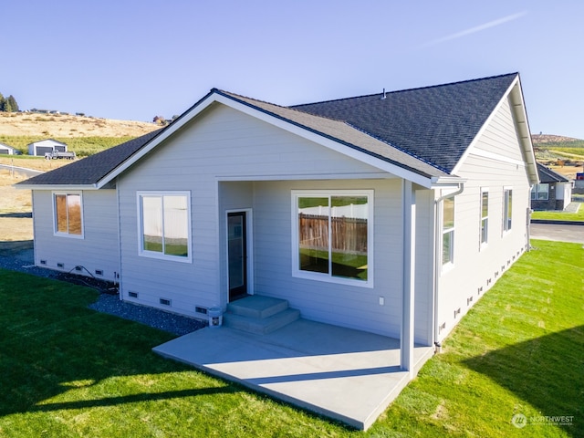 back of house with a yard and a patio