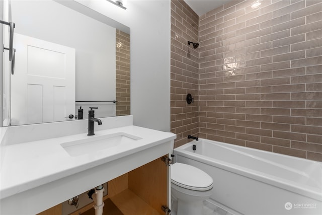 full bathroom featuring tiled shower / bath, vanity, and toilet