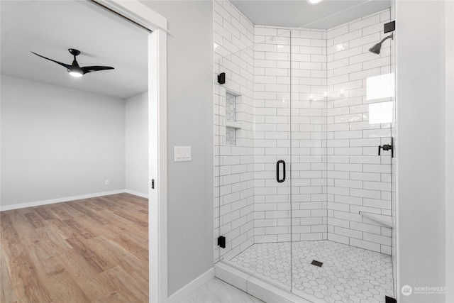 bathroom with ceiling fan, walk in shower, and hardwood / wood-style floors