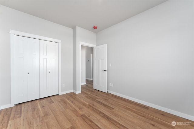 unfurnished bedroom featuring a closet and light wood-type flooring