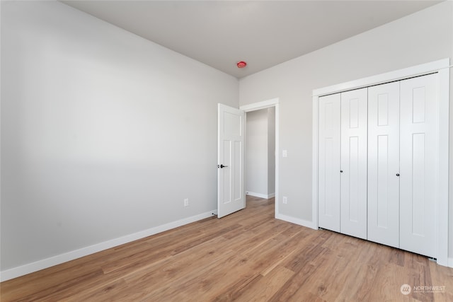 unfurnished bedroom featuring a closet and light wood-type flooring