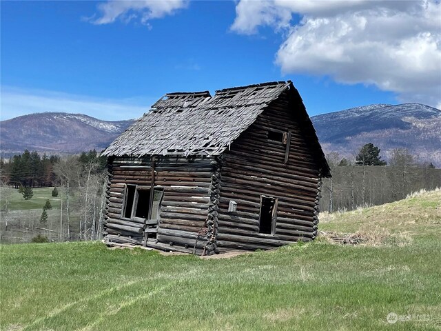 view of outdoor structure with a mountain view and a yard