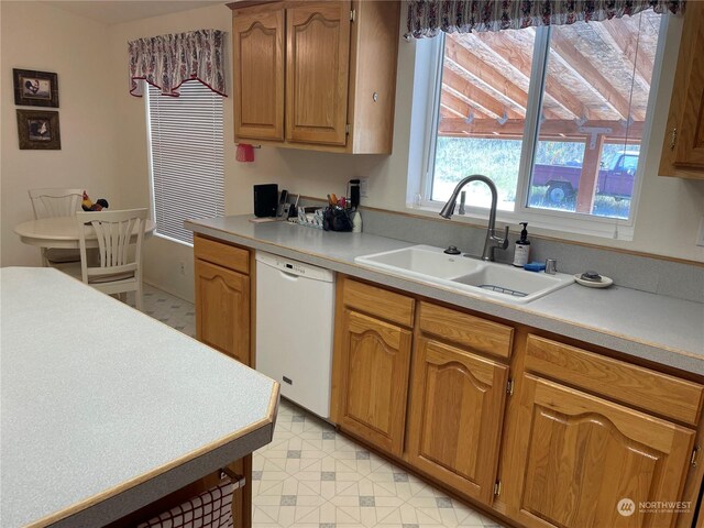 kitchen featuring light tile patterned flooring, dishwasher, and sink