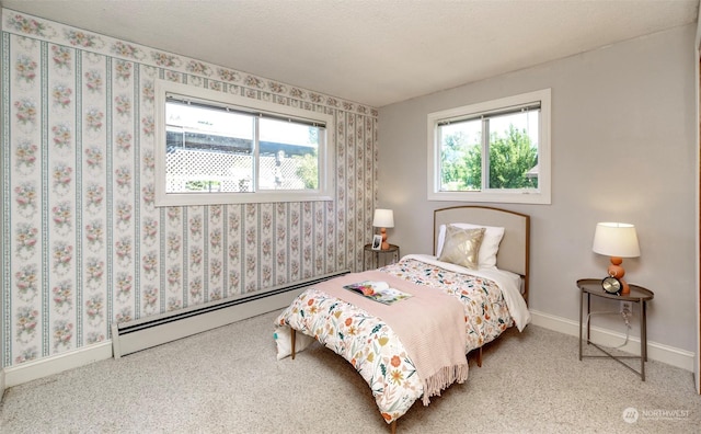 bedroom featuring baseboard heating, carpet floors, and a textured ceiling