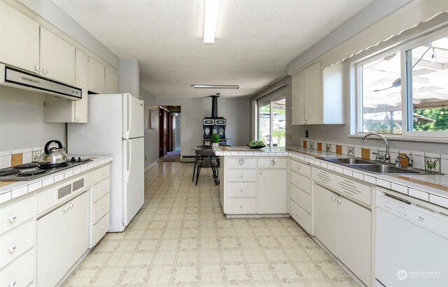 kitchen featuring white cabinetry, white dishwasher, and tile countertops