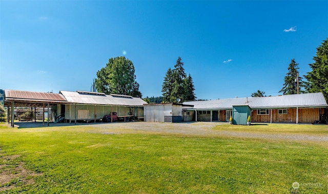 view of front of property with an outbuilding, a front lawn, and a carport