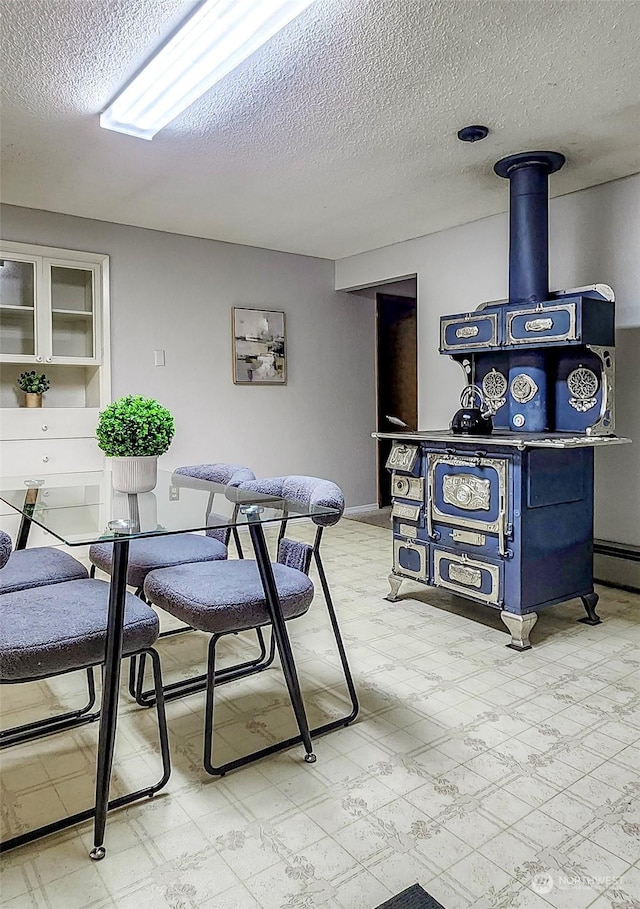 interior space with a textured ceiling and a wood stove