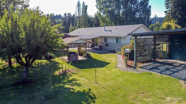 rear view of property featuring a gazebo, a lawn, and a carport