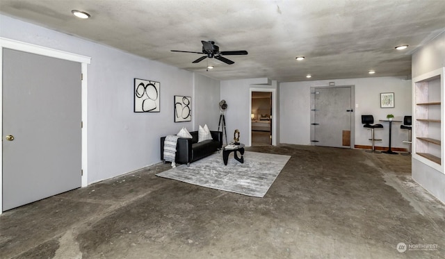 sitting room with ceiling fan and concrete floors