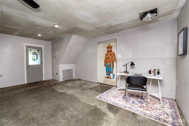 bonus room featuring a textured ceiling, vaulted ceiling, and concrete floors