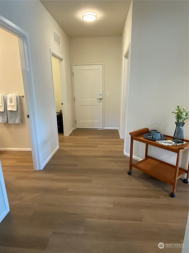 corridor with hardwood / wood-style flooring