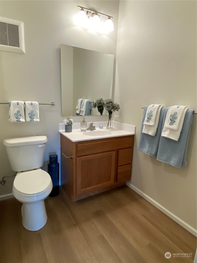 bathroom with hardwood / wood-style flooring, vanity, and toilet