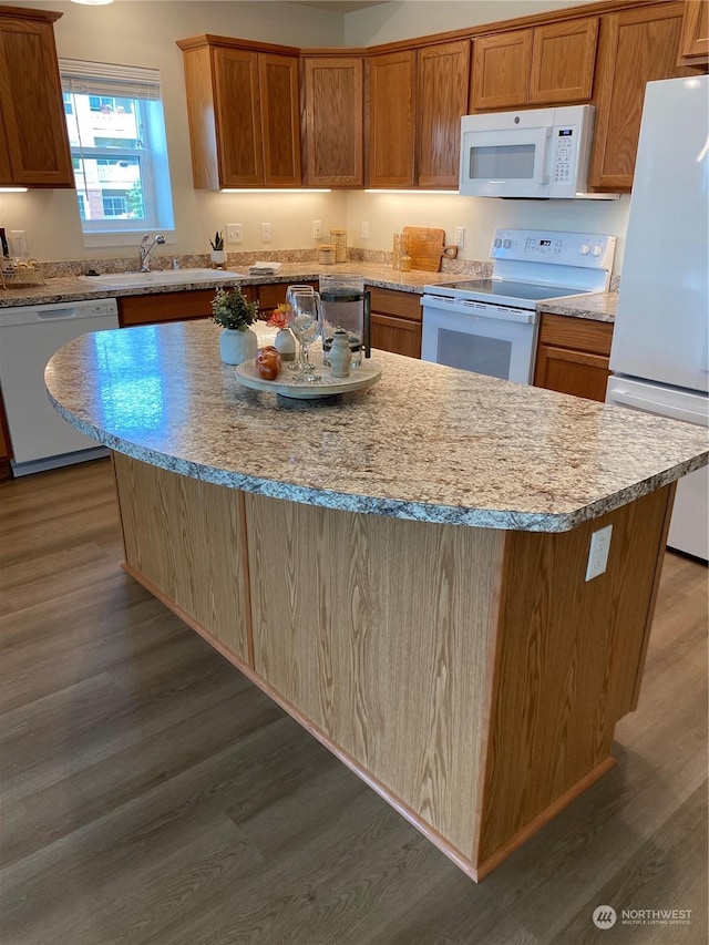 kitchen featuring sink, a kitchen island, dark hardwood / wood-style floors, and white appliances