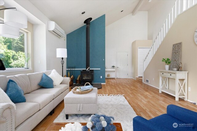 living room featuring beamed ceiling, high vaulted ceiling, a wood stove, a wall unit AC, and hardwood / wood-style flooring