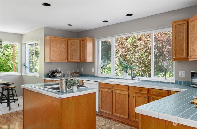 kitchen featuring tile countertops, sink, a kitchen island, and white dishwasher